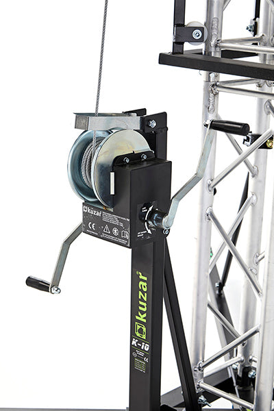 Close-up view of the heavy-duty manual steel-cable winch and safety brake handle mechanism mounted on the mast of the Kuzar K-10 tower lift. - imagen 5