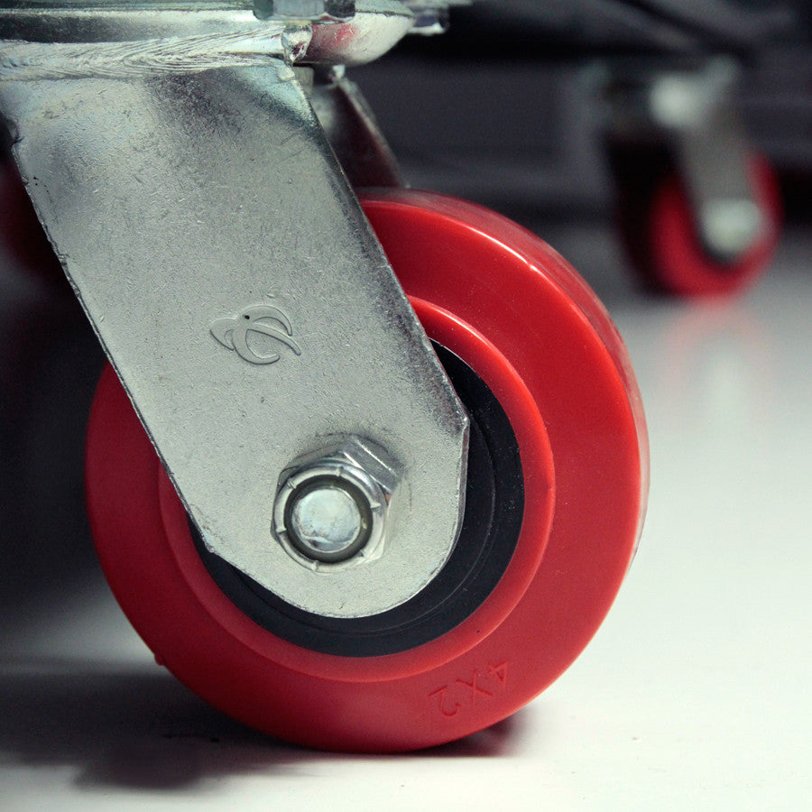 Close-up of a red wheel with metal axle on a blurred background