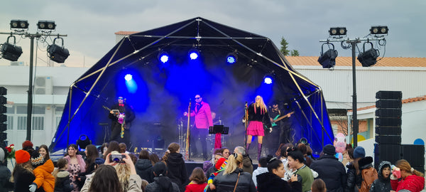 Konligo Fastival event structure with black membrane and outside backdrop hosting an energetic live band performance on an outdoor stage, with crowd gathered in front, now available on MTN SHOP US.