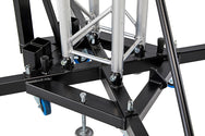 Detailed view of the rigid black steel base joints, locking pins, transport wheels, and adjustable leveling feet supporting the Kuzar K-10 tower lift. - imagen 6