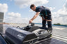 Person operating a solar panel installation robot on a rooftop