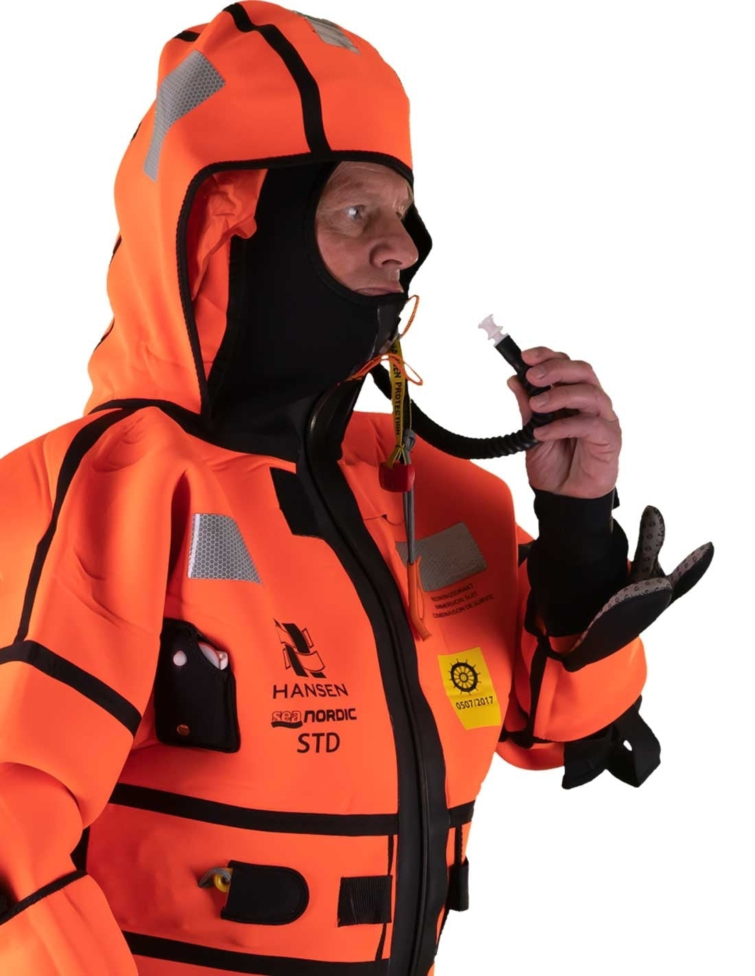 Hansen Protection SeaNordic Wet Suit 82606– A 6-hour immersion suit produced in extra strong flame-retardant neoprene. SeaNordic is equipped with an emergency light and has an integrated sprayhood that protects the face from waves and possibly seabirds. The hood has an innovative inflatable bladder for improved water tightness of the face seals, improved floatation and freeboard. The suit is certified for use without a lifejacket and is perfect as a survival suit on board fishing vessels, merchant ships and - imagen 3